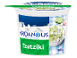 Greek style tzatziki sauce tub with cucumbers and garlic, against a Greek landscape.