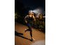 Woman running at night with a headlamp, wearing sportswear and trainers.