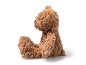 Soft brown teddy bear sitting in profile on a white background.