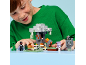 A smiling boy plays with a block building set featuring fantasy figures.