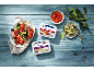 Greek-style aubergine and tomato spreads with grilled vegetables on a blue wooden background.