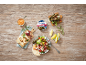 Greek-style stuffed vine leaves with rice, salad, bread, and dip on a wooden table.
