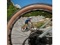 Cyclist on a mountain bike on an asphalt road, shot through a wheel.