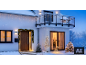 Outdoor Christmas lights and glowing decorations adorning a snowy house.