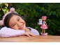 Smiling girl with a headband and a doll with an animal figure.