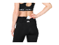 Woman in black sportswear, inserting a card into the back pocket of her leggings.