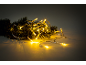 Christmas string lights with pine needles on a dark background.