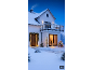 House in winter with Christmas lights, including string lights, trees, and an illuminated deer.