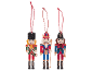 Three wooden Christmas ornaments shaped like nutcrackers on a black background.