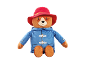 A plush toy bear wearing a red hat and a blue coat.