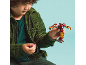 Boy in green corduroy jacket playing with a superhero action figure.