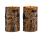 Two LED candles with a birch bark look on a black background