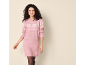 Woman in a pink knitted dress with snowflake pattern and black tights.