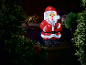 Illuminated Santa Claus Christmas decoration with foliage and pine cones
