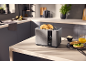 Toaster with bagels in a modern kitchen, with orange juice and avocado.