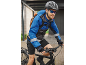 Man on a bike wearing a blue jacket, helmet, sunglasses, and a backpack.