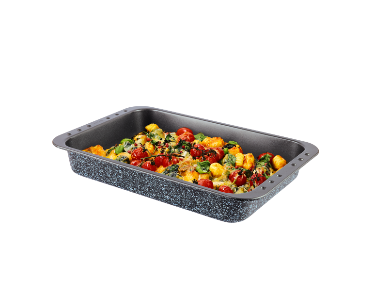Baking dish with gnocchi, cherry tomatoes, spinach, and cheese.