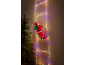 Christmas light ladder with climbing Santa figure next to a Christmas tree.