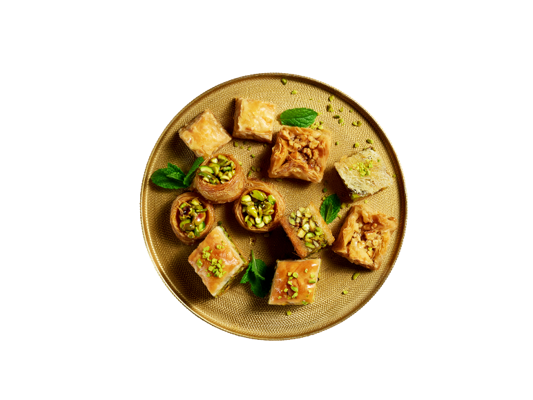 Assortment of baklava and oriental sweets with pistachios and walnuts on a golden platter.