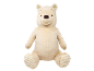 Cream-colored plush bear toy with a brown nose and closed eyes, sitting upright.