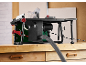 Table saw with a suction hose on a wooden workbench.