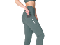 Woman in teal sports leggings with a phone in the side pocket, and a reflective stripe.
