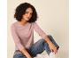 Woman in a pink long-sleeved top and blue jeans, sitting on the floor.