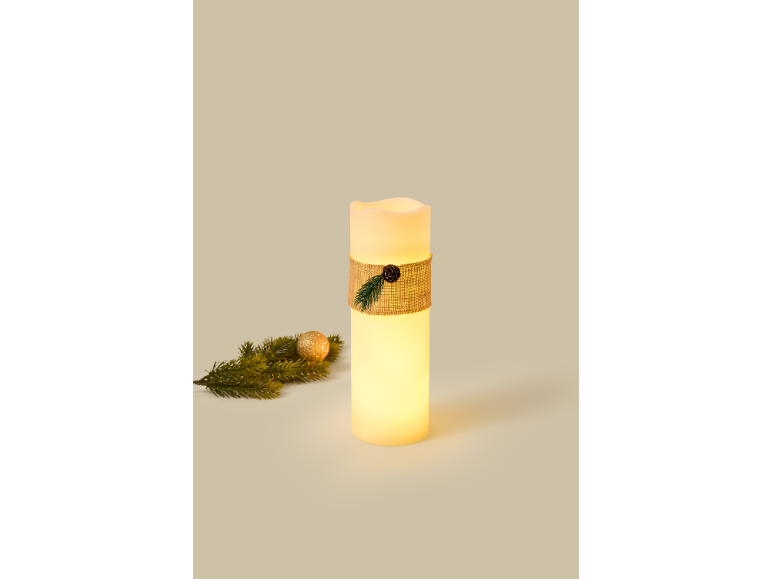 Glowing LED candle with jute ribbon and a small fir branch.