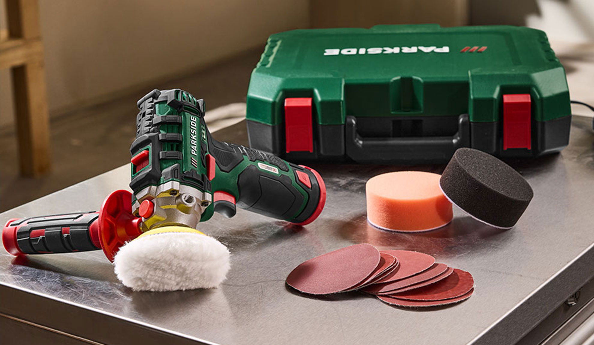 Cordless polisher with accessories, including polishing pads and sanding discs.