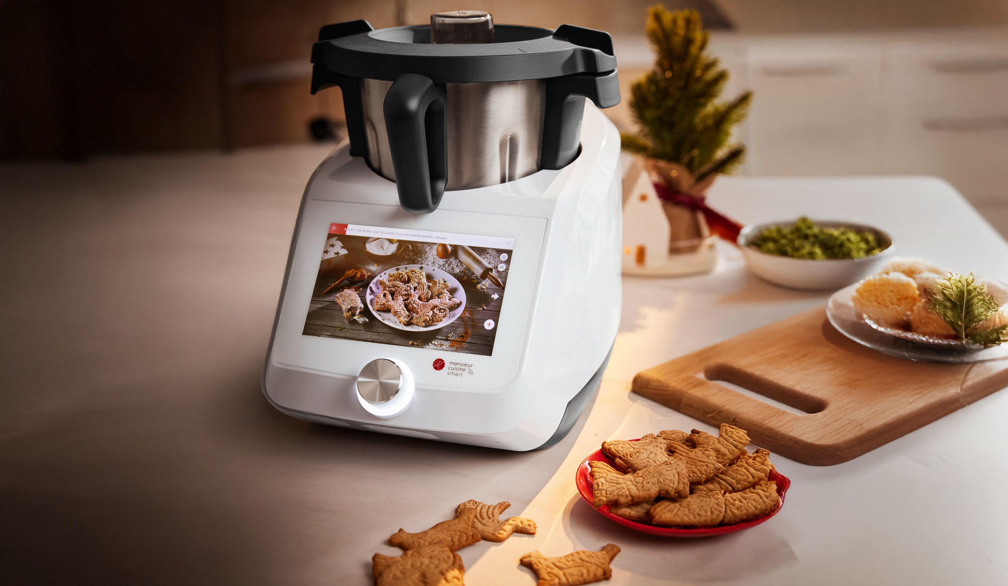 Monsieur Cuisine Smart kitchen machine with touchscreen, cookies, and Christmas decorations.