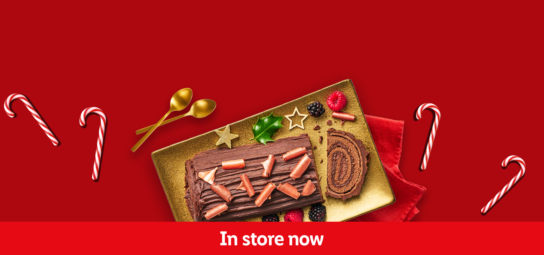 Christmas desserts: chocolate yule log and berry cheesecake on gold plates, with candy canes.