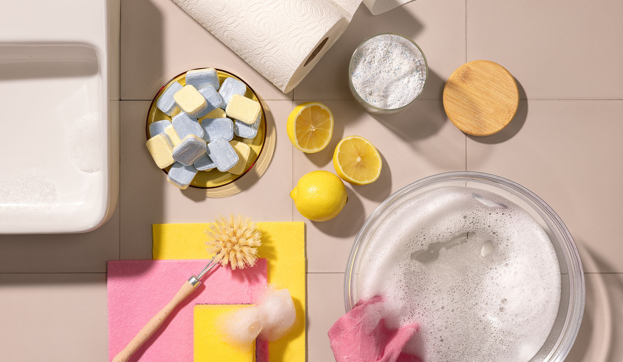 Cleaning supplies: dishwasher tablets, lemons, powder, and sponges.