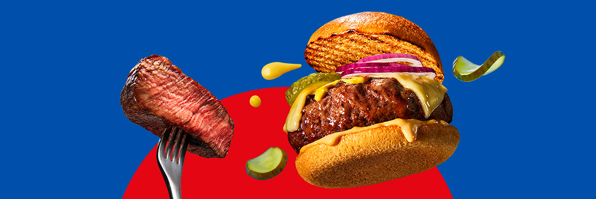 A burger with cheese, onions, and pickles, next to a steak on a fork.
