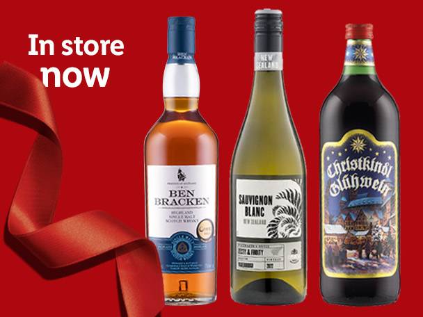 Whisky, Sauvignon Blanc wine, and Glühwein bottles with a red ribbon, 'In store now' text.