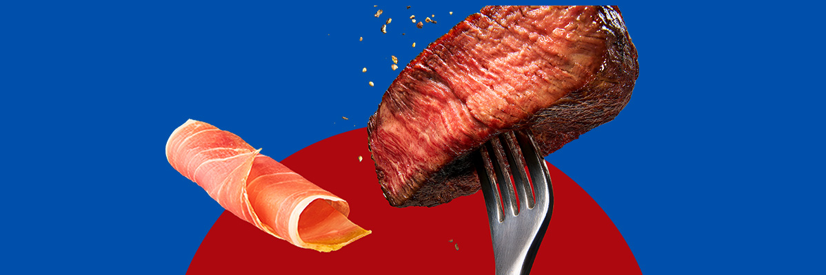 Steak on a fork with seasoning and a roll of prosciutto on a blue and red background.