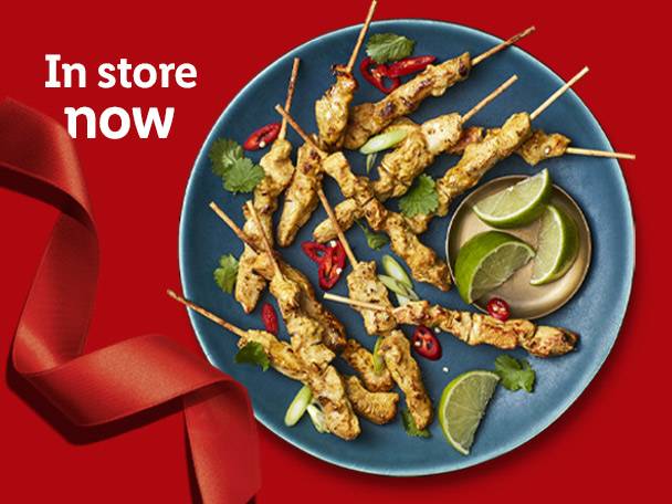 Chicken satay skewers with lime and chili on a blue plate, with 'In store now' text.