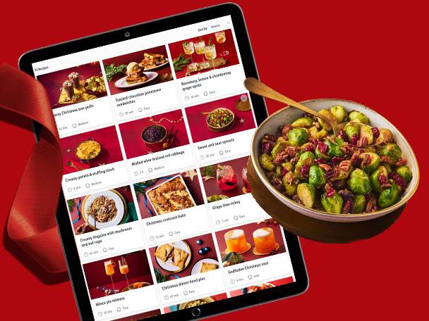 Tablet displaying Christmas recipes next to a bowl of Brussels sprouts.