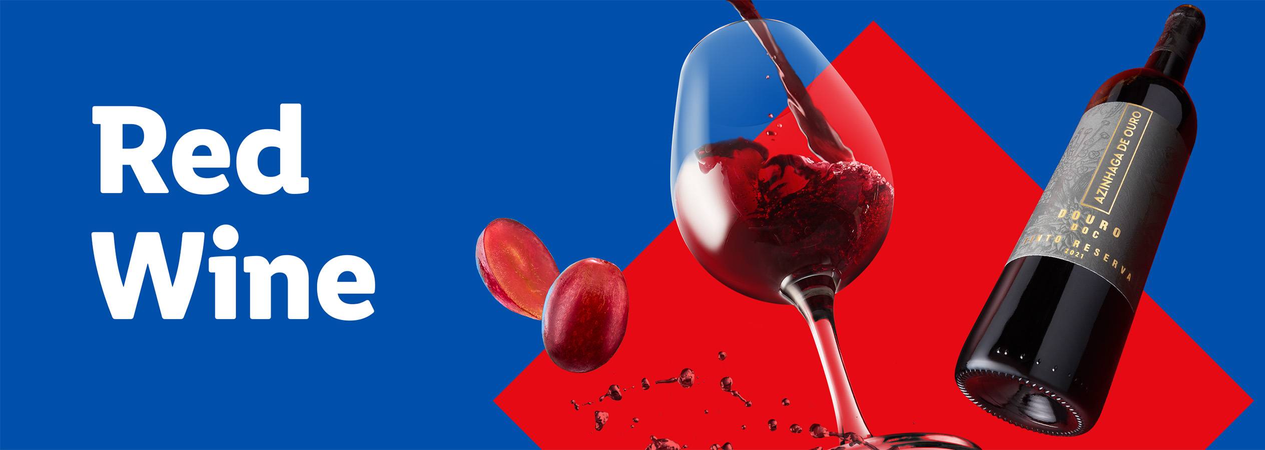 Red wine being poured into a glass, with a bottle of Azinhaga de Ouro wine and grapes.