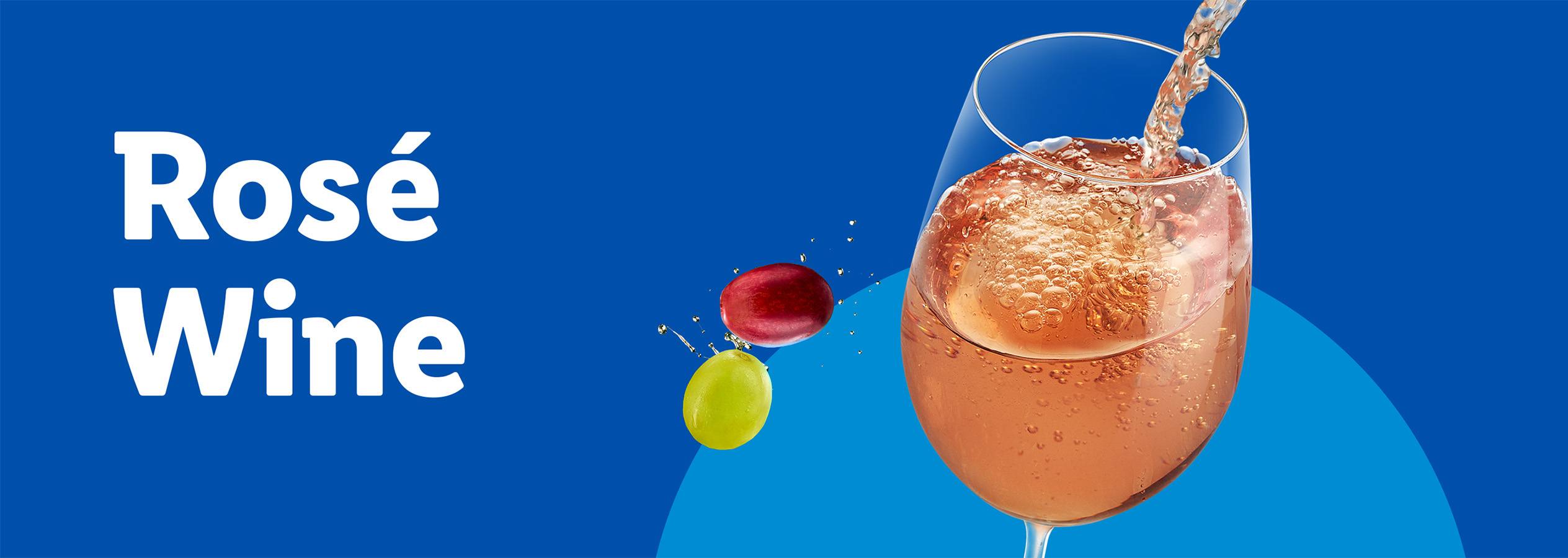 Rosé wine being poured into a glass with grapes on a blue background.