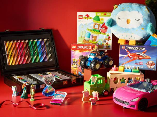 A collection of toys including a large art set, Lego Duplo, Lego Ninjago, a plush owl, and a pink toy car.