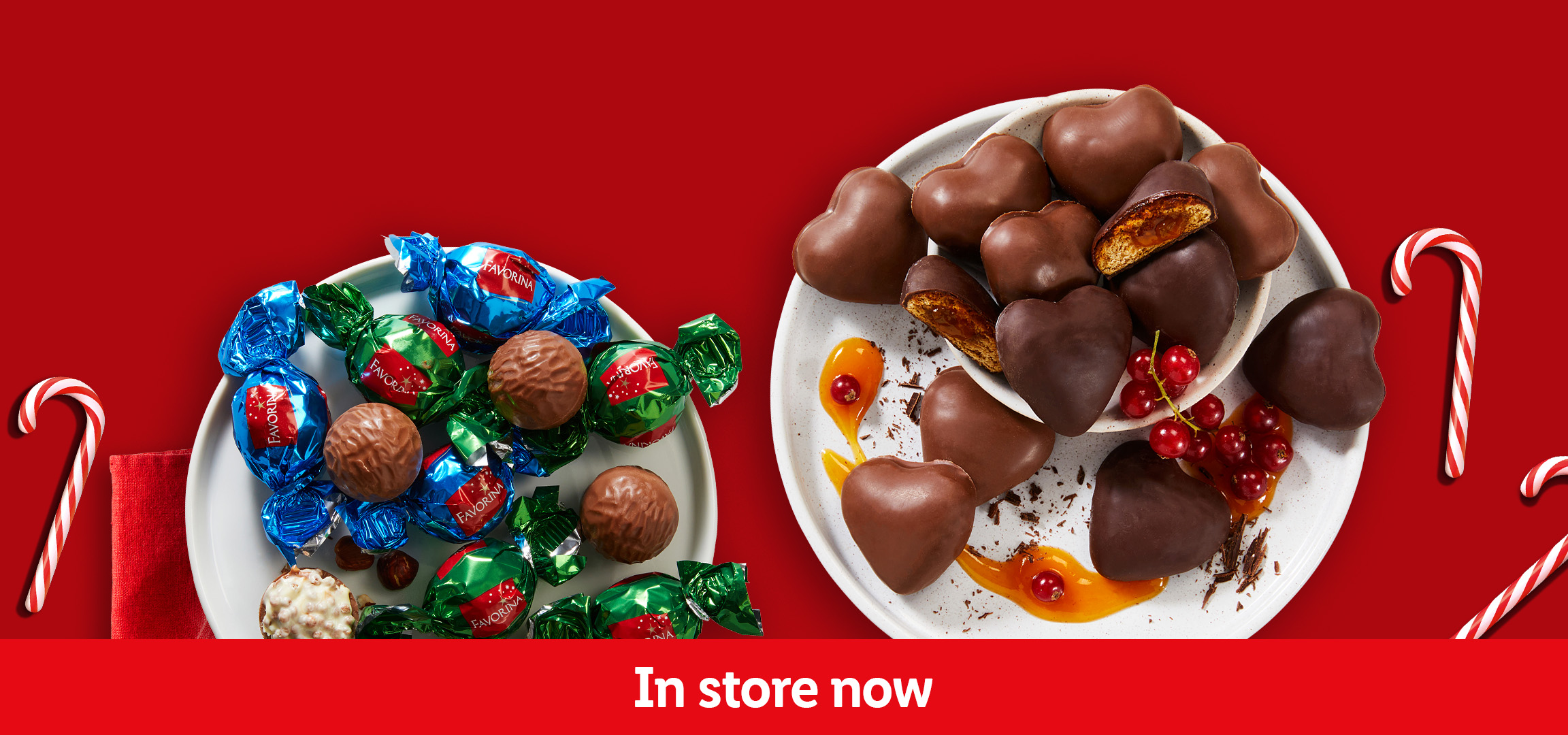 Favorina chocolates and heart-shaped gingerbread cookies with candy canes on a red background.