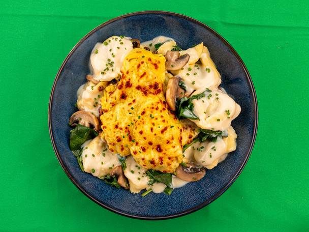 Tortellini with creamy sauce, mushrooms, spinach, and a baked cheesy topping.