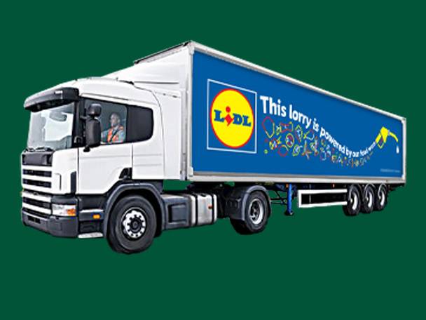A white Lidl truck with a blue trailer, featuring the text 'This lorry is powered by our food waste'.