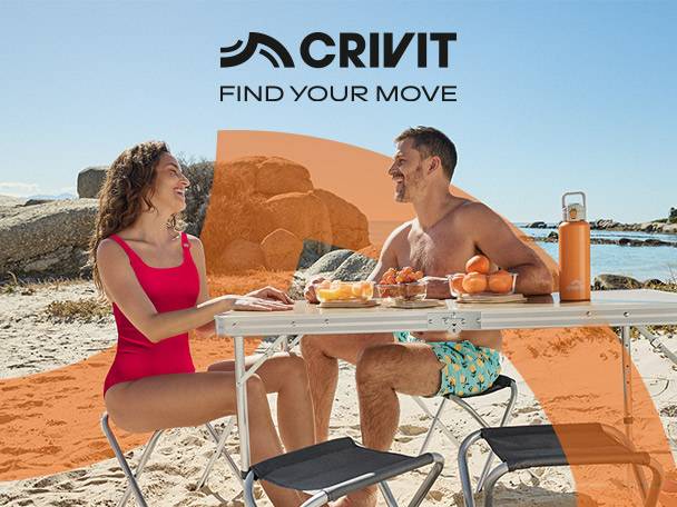 Couple enjoying a beach picnic with a portable table, chairs, and a water bottle.