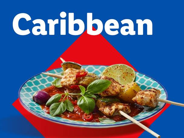 Caribbean-themed dish with chicken skewers, vegetables, and sauce on a blue and red background.