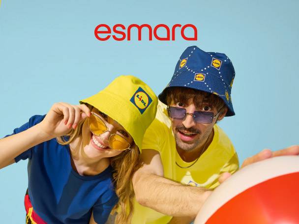 Two people in bucket hats and sunglasses, holding a beach ball, smiling at the camera.