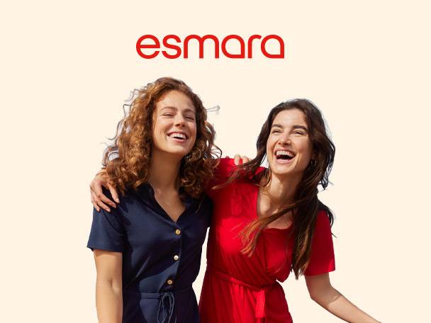 Two women in dresses, one navy and one red, laughing together.