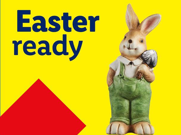 Easter ready: A bunny figurine in green overalls holding a shovel on a yellow background.