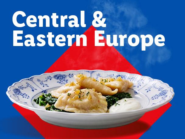 Steaming pierogi with spinach and sour cream on a plate, with text 'Central & Eastern Europe'.