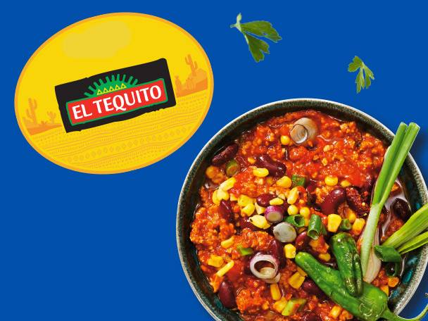 El Tequito chili con carne in a bowl, garnished with green onions and peppers.